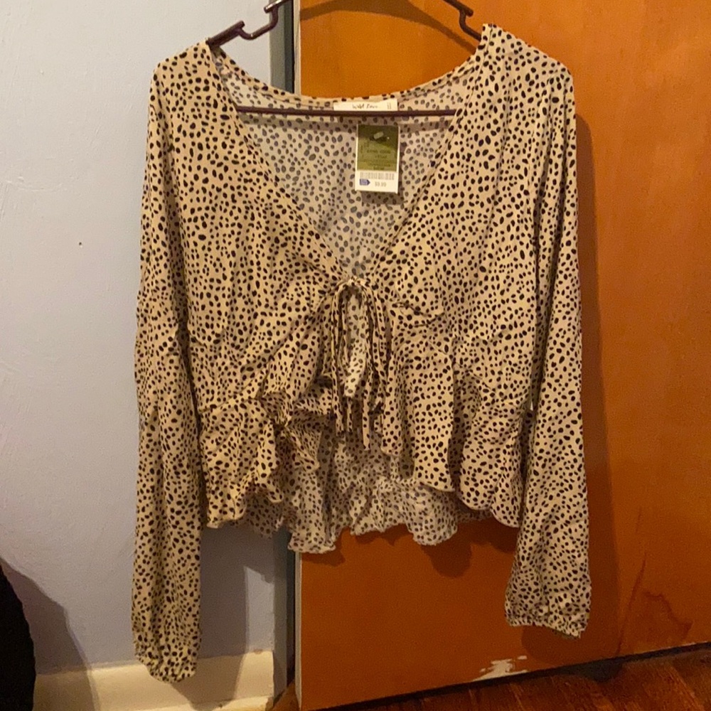 a spotted over shirt with a little tie in the front